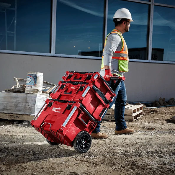 Tradesman moving a Milwaukee PACKOUT stack across a job site